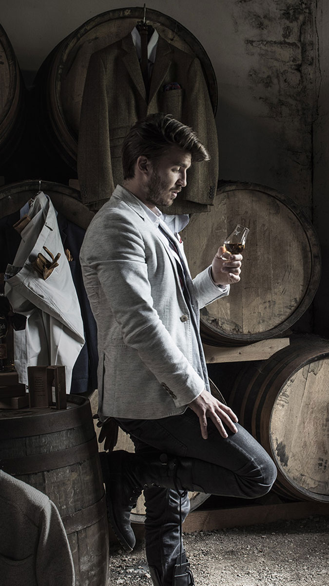 Man in suit inspecting dram of whisky